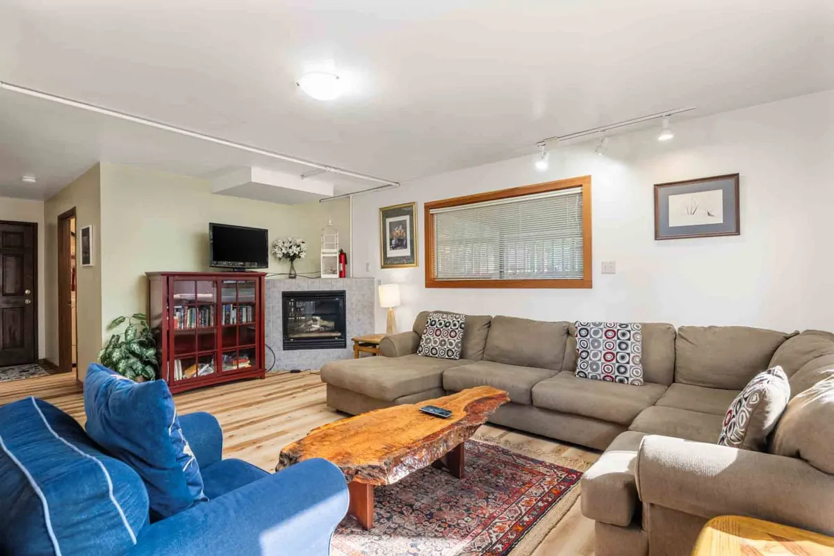 A modern, inviting family room featuring a fireplace, soft sofa, coffee table, and a TV. The space is designed for both movie marathons and game nights, with an atmosphere that feels private and family-friendly.